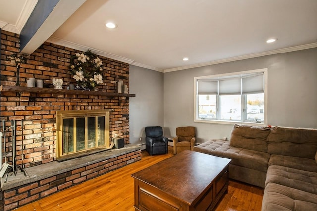 living room with ornamental molding, recessed lighting, wood-type flooring, and a fireplace