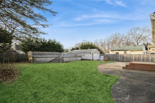 view of yard with an outbuilding, a fenced backyard, and a fenced in pool