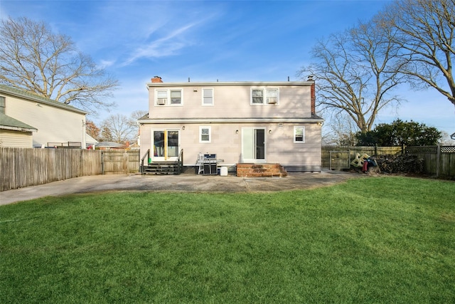 rear view of property with entry steps, a fenced backyard, a chimney, and a lawn