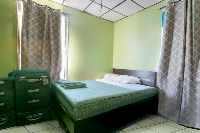 tiled bedroom featuring a drop ceiling