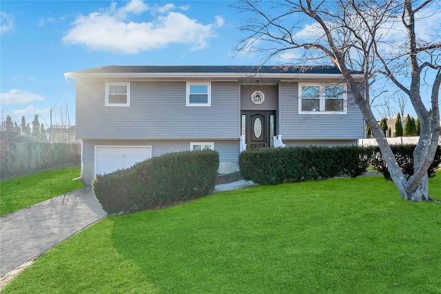 bi-level home featuring a garage and a front lawn