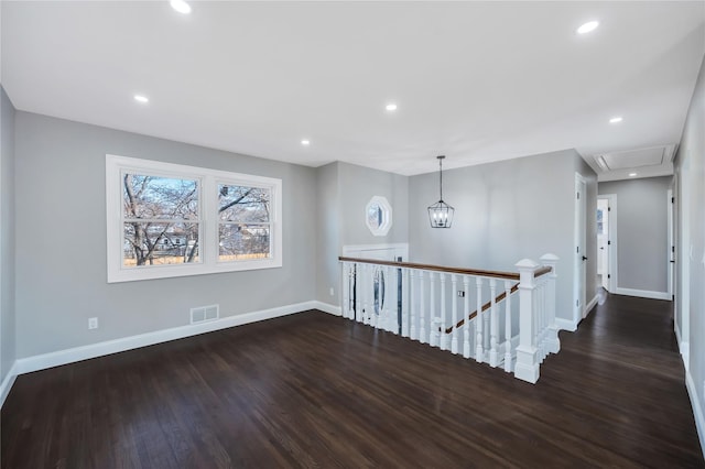 corridor featuring dark hardwood / wood-style flooring and a notable chandelier