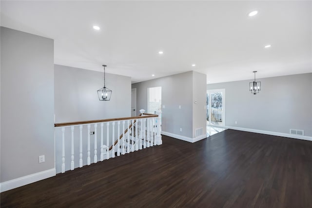 unfurnished room with dark hardwood / wood-style floors and a chandelier