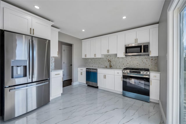 kitchen with stainless steel appliances, tasteful backsplash, sink, and white cabinets