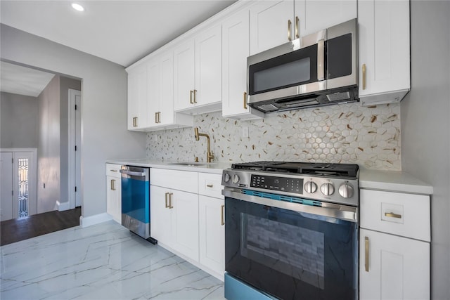 kitchen featuring appliances with stainless steel finishes, sink, white cabinets, and backsplash