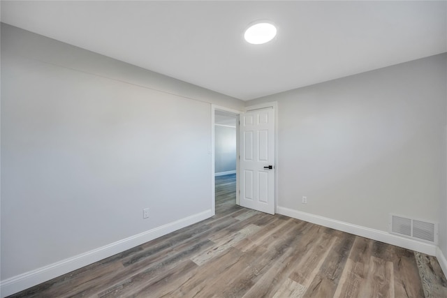 unfurnished room with wood-type flooring