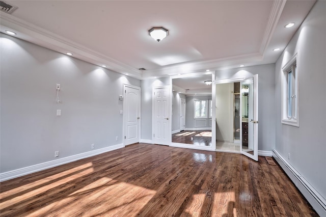 spare room featuring hardwood / wood-style flooring, ornamental molding, and a baseboard heating unit