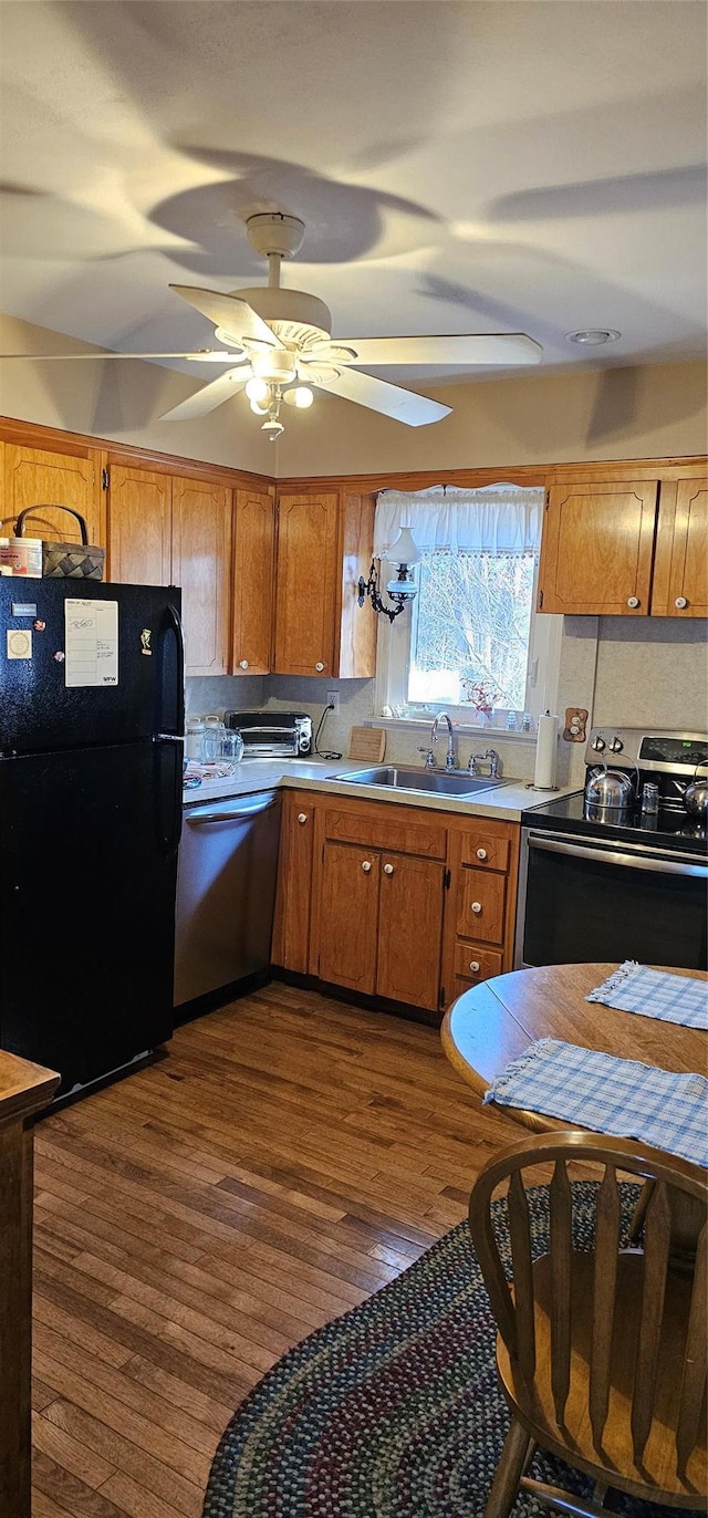 kitchen featuring appliances with stainless steel finishes, sink, dark wood-type flooring, and ceiling fan