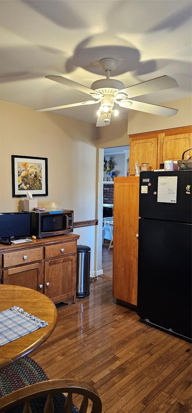 kitchen with black fridge, ceiling fan, and dark hardwood / wood-style flooring