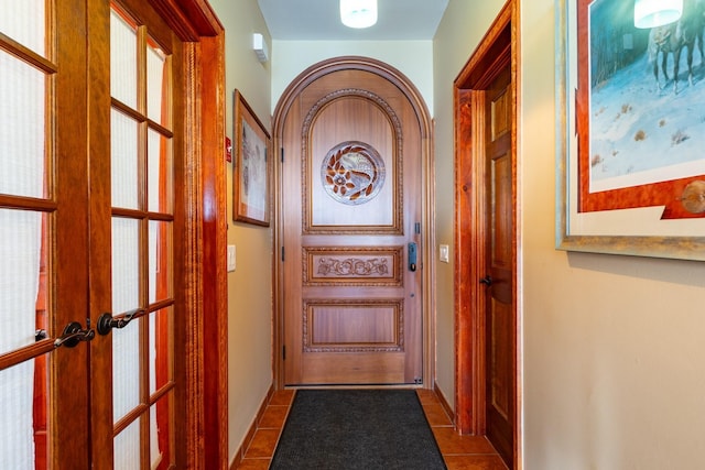 doorway featuring dark tile patterned flooring and french doors