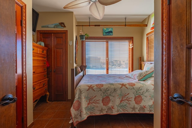 tiled bedroom featuring ceiling fan