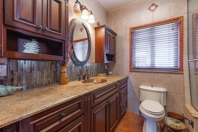 bathroom with vanity, tile patterned floors, tile walls, and toilet