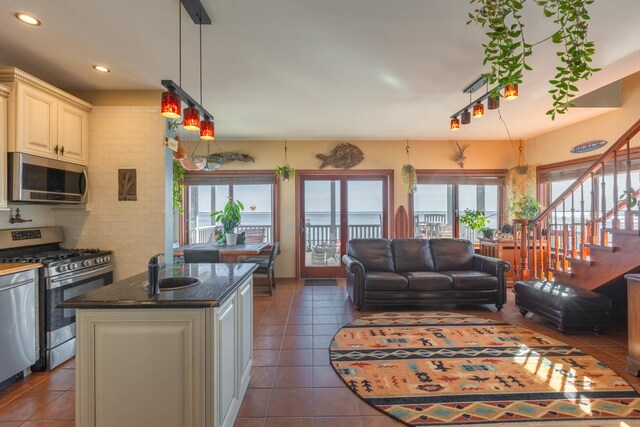 49 Bayview Ave W, Lindenhurst, NY 11757 - kitchen with appliances with stainless steel finishes, cream cabinets, plenty of natural light, dark tile patterned flooring, and recessed lighting