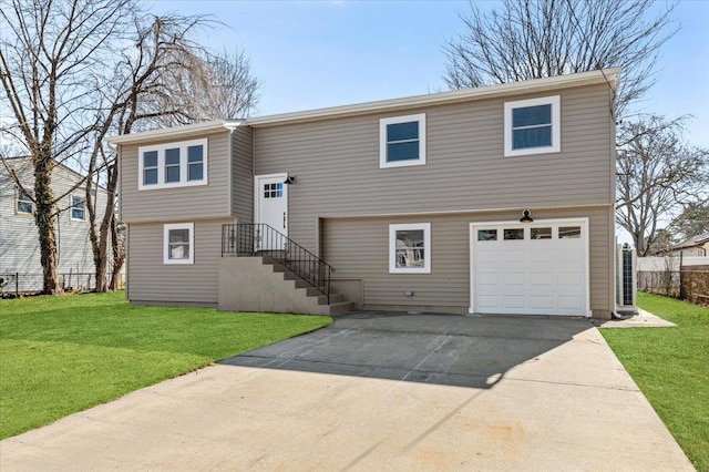 bi-level home featuring driveway, a garage, and a front lawn