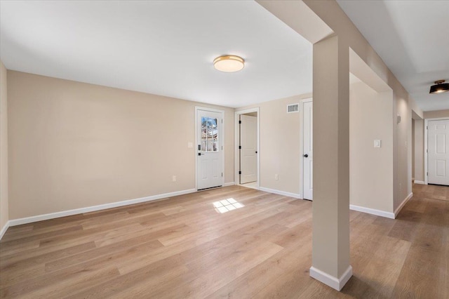 foyer with light wood finished floors, baseboards, and visible vents