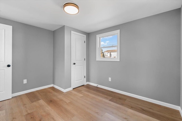 unfurnished bedroom with light wood-style flooring and baseboards