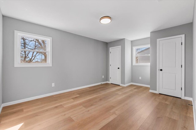 unfurnished bedroom featuring light wood-style flooring and baseboards