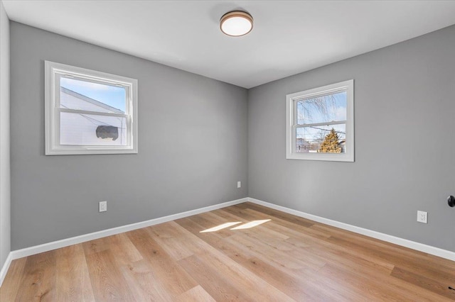 spare room featuring wood finished floors and baseboards