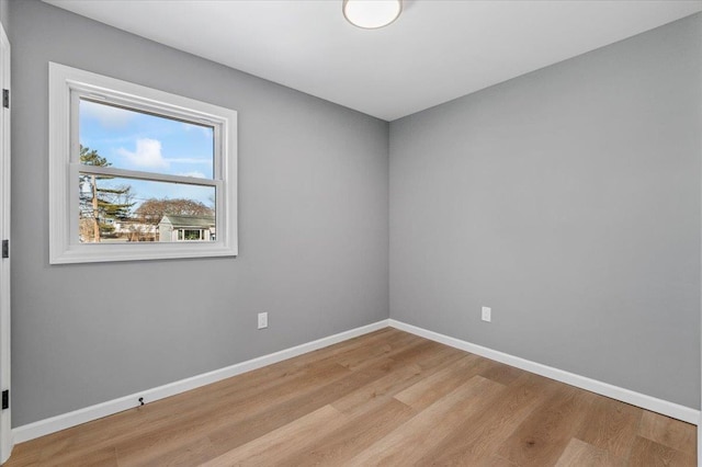 empty room with light wood finished floors and baseboards