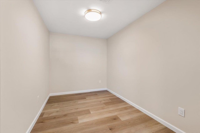 spare room featuring baseboards and light wood-style floors