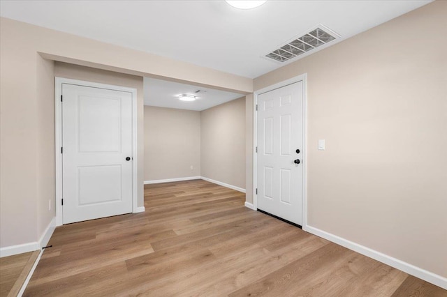 interior space with light wood-style flooring, visible vents, and baseboards