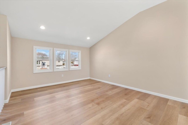 spare room featuring light wood-type flooring, recessed lighting, baseboards, and lofted ceiling