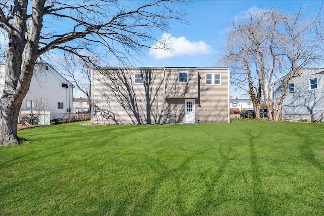 back of house with fence and a lawn