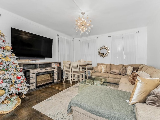 living room featuring dark wood-type flooring, a fireplace, and a notable chandelier