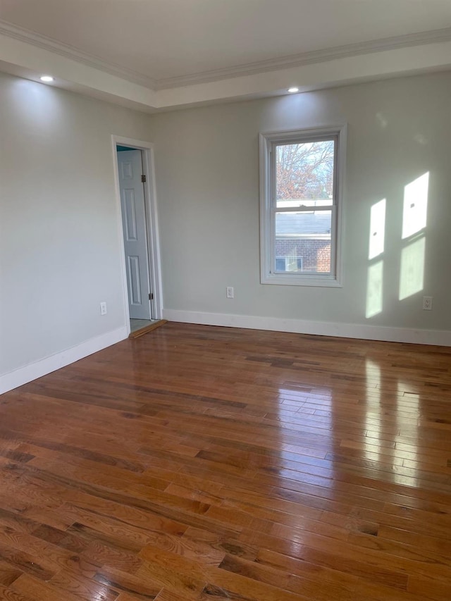 empty room featuring dark hardwood / wood-style flooring and ornamental molding