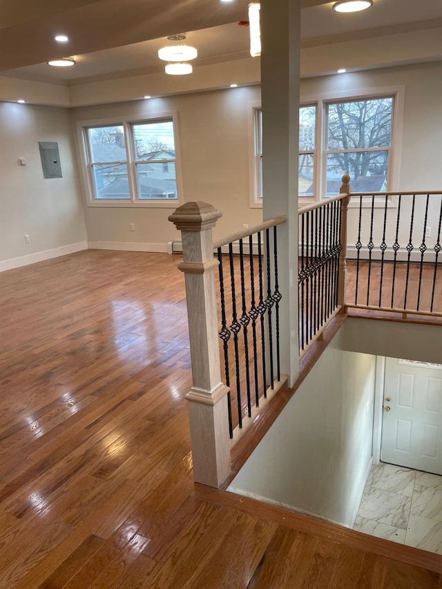 stairway with hardwood / wood-style floors and electric panel