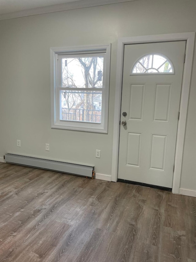 entrance foyer featuring wood-type flooring, ornamental molding, and baseboard heating