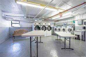 community laundry room featuring separate washer and dryer and a sink