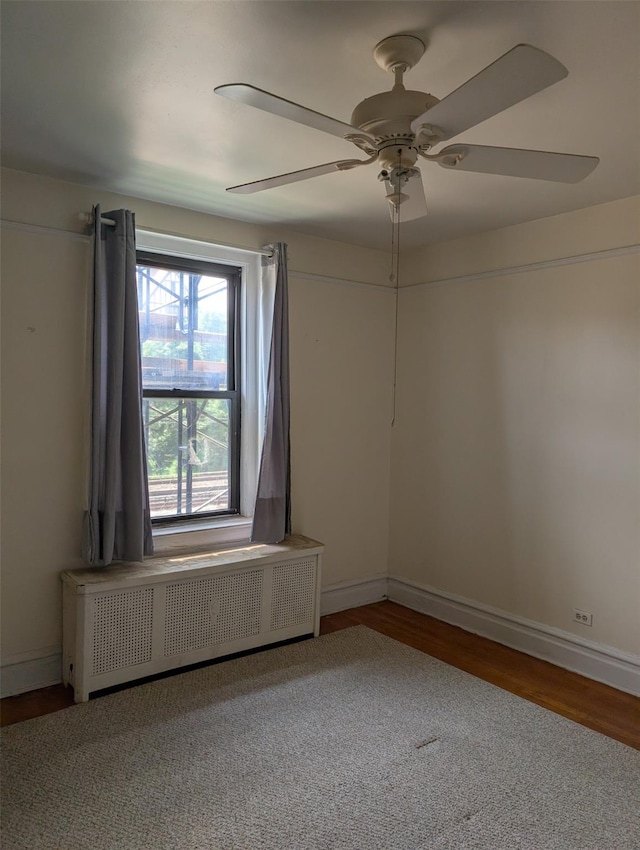 72-34 Austin St Unit D4, Forest Hills, NY 11375 - unfurnished room featuring radiator heating unit, wood finished floors, and a ceiling fan