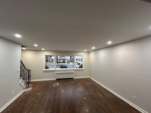 interior space with radiator and hardwood / wood-style floors