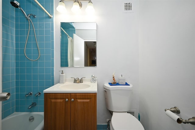 full bathroom featuring vanity, tiled shower / bath combo, and toilet