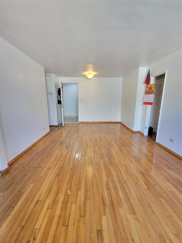 unfurnished living room with light wood finished floors and baseboards