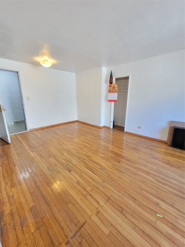 unfurnished living room with light wood finished floors and baseboards