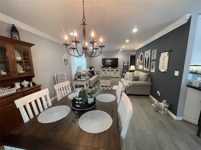 dining space featuring wood-type flooring, crown molding, and a chandelier