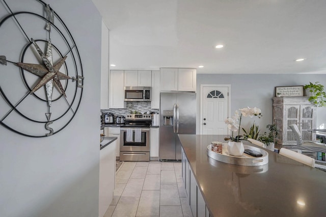 kitchen with white cabinetry, tasteful backsplash, light tile patterned flooring, and appliances with stainless steel finishes