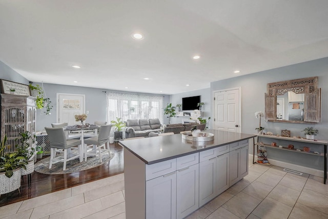 kitchen with light tile patterned flooring, a center island, and gray cabinetry