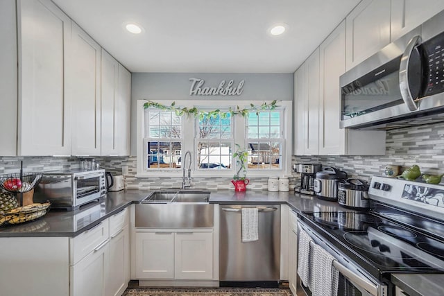 kitchen featuring tasteful backsplash, stainless steel appliances, sink, and white cabinets