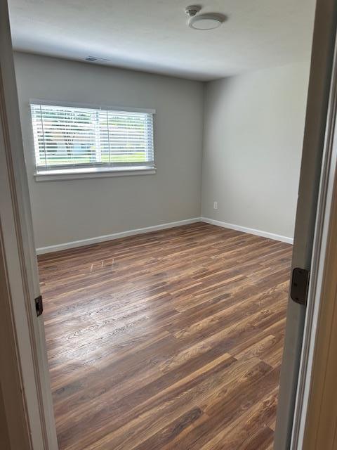 unfurnished room with dark hardwood / wood-style floors