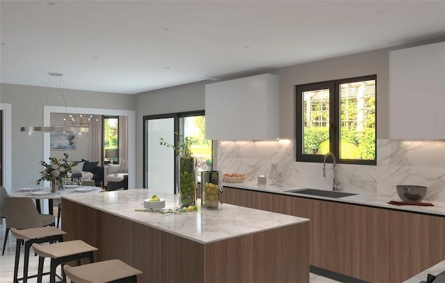 kitchen with a center island, sink, white cabinets, and a breakfast bar