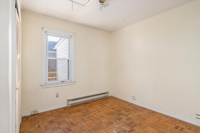 spare room with a baseboard heating unit, crown molding, and parquet floors