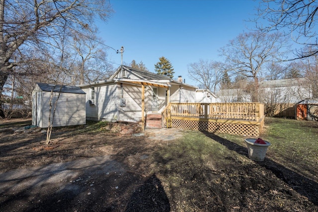 rear view of house featuring a wooden deck, a storage shed, and a yard