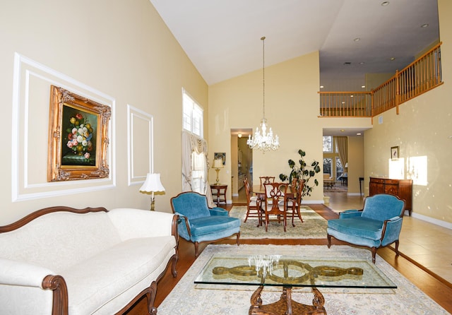 living room with hardwood / wood-style floors, high vaulted ceiling, and a chandelier