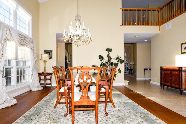 dining space with an inviting chandelier, dark hardwood / wood-style flooring, and a high ceiling