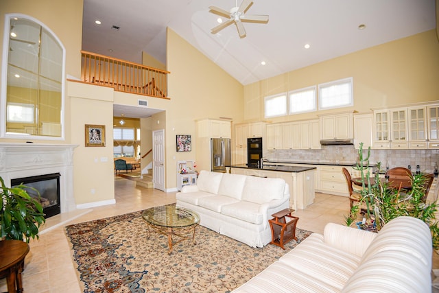 tiled living room with a high ceiling, sink, and ceiling fan