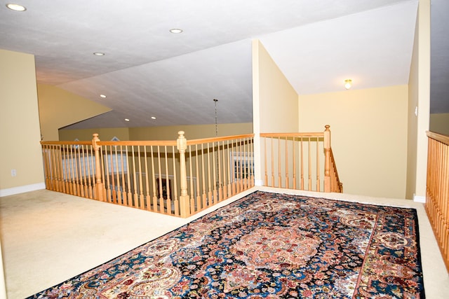 hallway with lofted ceiling and carpet flooring