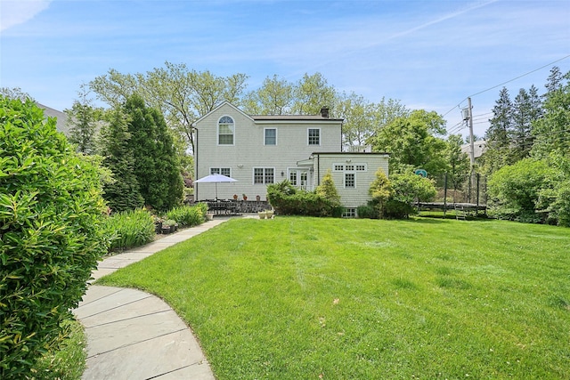 rear view of house with a patio and a yard